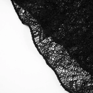 Detailed close-up of intricate black floral lace fabric with delicate cutout patterns
