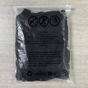 Detailed view of backless lace dress in transparent polybag with safety warning labels