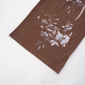 Détail de l'imprimé fleuri sur tissu marron avec des accents étoilés et ourlet lisse