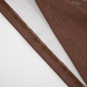 Gros plan du tissu en maille marron montrant la texture et les détails de couture