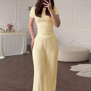 Pale yellow two-piece lounge set with short sleeve top and wide-leg knit trousers