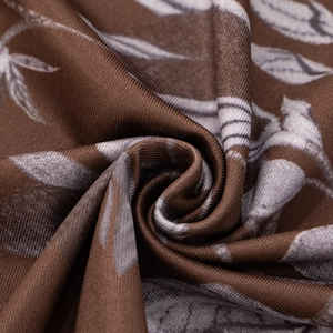 Détail d'un tissu imprimé floral marron haute densité avec texture soie et éclat doux