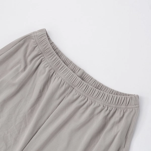 Detail of wide elastic waistband and soft gray knitted fabric of the wide-leg trousers