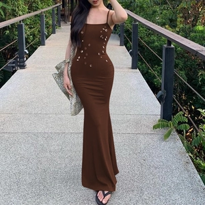 Detail of slim fit coffee brown maxi dress featuring side cutouts and sequin decor
