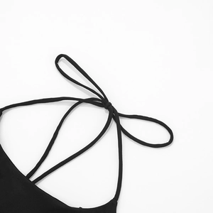 Détail de la robe noire élégante avec bretelles croisées et nœud papillon soigné au dos