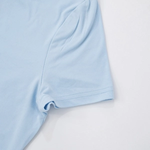 Detailed close-up of double-stitched sleeves on a soft light blue cotton blend tracksuit