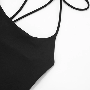 Détail d'une robe dos nu noire élégante montrant le tissu tricoté élastique et les brides