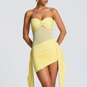 Detail of yellow strapless dress with mesh panel, ruching, and elegant fringe accents