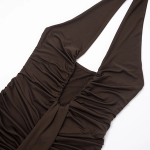 Detail of elegant dark brown halter neck dress showing ruched fabric and plunging V-neck