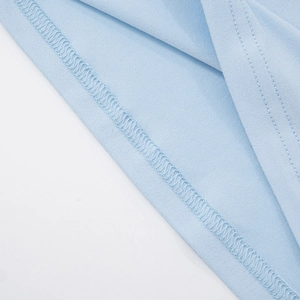Detailed macro view of the double stitching and sewing finish on light blue knit fabric