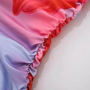 Close-up of vibrant gradient tie-dye floral print on elastic smocked dress fabric