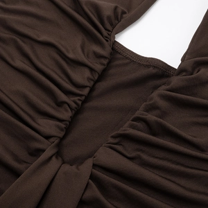 Detail of elegant brown ruched dress fabric showing fine stitching and pleated texture