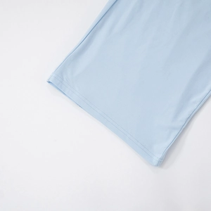 Detail shot of light blue knit fabric showing precise double-needle stitching and texture
