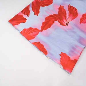 Detail of red floral print on blue fabric with ruffled edge for women's A-line maxi dress