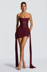 Detail of burgundy tube mini dress featuring sheer mesh inserts and long side sashes