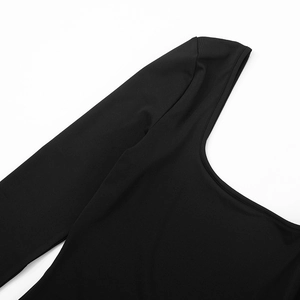 Detail view of the deep U-neckline and smooth black stretch fabric of the long sleeve romper