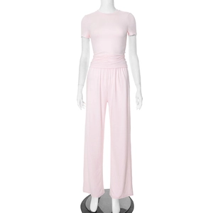 Detail view of pink crewneck top and high waist wide leg trousers on a mannequin