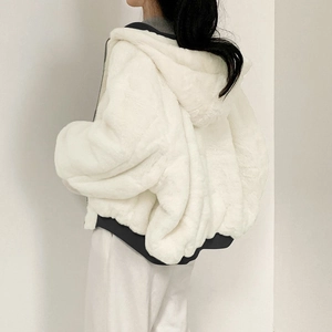 Detail of white faux fur hoodie jacket with black contrast hem and oversized hood design