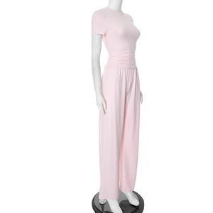 Detailed side view of pink two-piece set with fitted top and flowing wide-leg pants