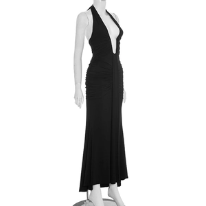 Detail of elegant black halter neck maxi dress featuring deep V-neck and ruched texture