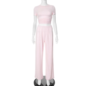 Detail of light pink high-waisted wide leg pants and matching crop top in soft fabric