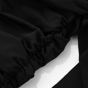 Macro shot of black ribbed knit fabric with Ruched elastic stitching details on the dress