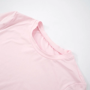 Detail of the crew neck collar and stitching on a soft pink short sleeve knit t-shirt