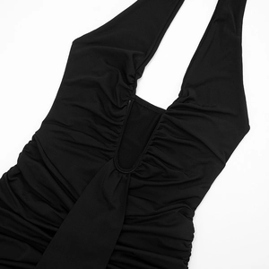 Detailed macro view of the elegant black halter neck dress with intricate ruched fabric texture