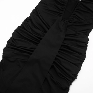Detailed close-up of the black dress featuring elastic ruching and refined sewing texture