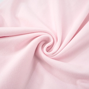 Macro detail of soft light pink knitted fabric texture showing premium weave and drape