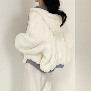 Close-up of the white plush hooded jacket featuring premium faux fur texture and loose fit
