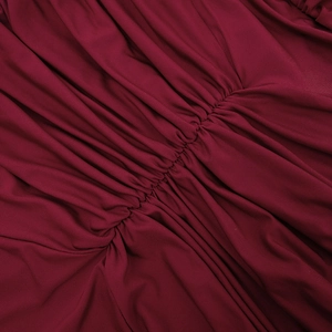 Detailed view of the dark red dress fabric featuring professional ruched and pleated textures