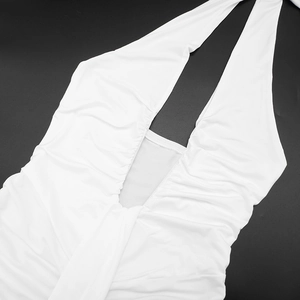 Detail view of white ruched V-neck halter dress featuring elegant pleated fabric texture