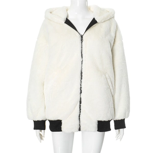 Detail of white faux fur jacket featuring black metal zipper and ribbed elastic cuffs
