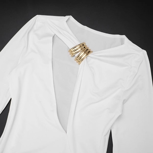Detail of elegant white long sleeve dress featuring gold metal rings and deep V-neckline