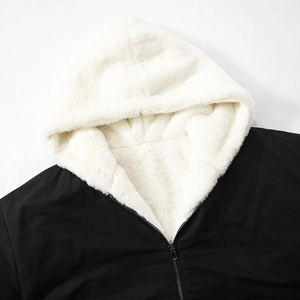 Detail of hooded jacket with black outer fabric, white faux fur lining and metal zipper