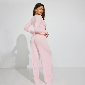 Detail view of pink two-piece loungewear set featuring soft knit long-sleeve top and wide trousers
