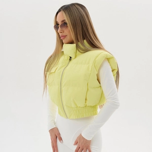 Detail of light yellow quilted vest featuring a stand collar and zip pocket decoration