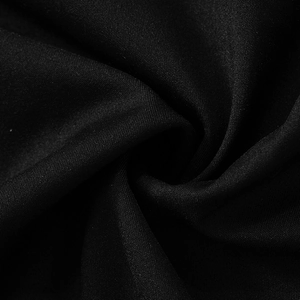 Vista macro della trama del tessuto nero che mostra la trama piana liscia e i riflessi
