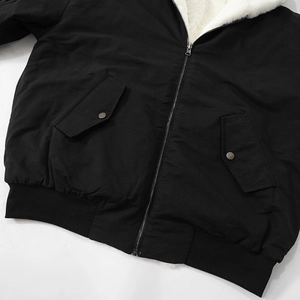 Close-up of black worker jacket with warm white fleece lining and metal zipper closure