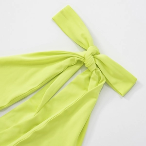 Detailed close-up of the knot design on a vibrant lime green halter neck dress fabric