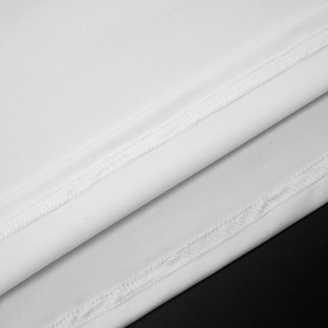 Close-up of professional triple-needle stitching on elegant white knit dress hem