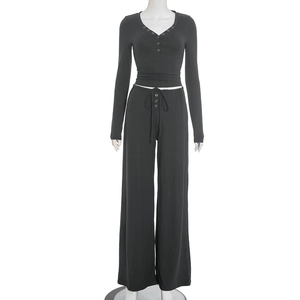 Detail of black V-neck buttoned crop top and drawstring wide-leg pants set texture