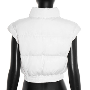 Macro detail of the white quilted puffer vest showing the stand collar and elastic hemline