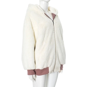 Close-up of white plush hooded jacket featuring zipper and soft ribbed cuffs for winter warmth