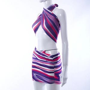 Detail van cross-halter crop top en geplooide minirok met paarse gestreepte print