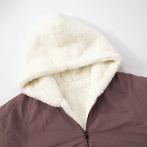 Close-up of metal zipper and thick white faux shearling lining on hooded brown jacket