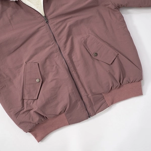Detailed macro shot of dust rose jacket featuring silver zipper and plush white lining