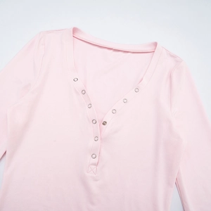 Detail of pink Henley neck top with silver metal snap buttons and cotton fabric texture