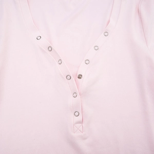 Detail view of pink knit top featuring a V-neckline and silver metal snap buttons